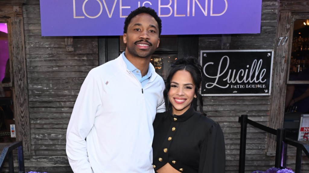Lydia Velez in a black dress posing at SXSW with Milton Johnson, who is wearing a white button up