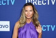 Britani Bateman in a purple dress in front of a blue backdrop