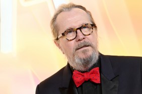 Gary Oldman in a black suit and red polka dot tie