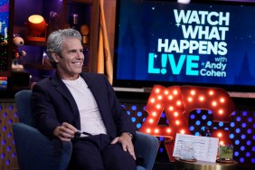 Andy Cohen on Watch What Happens Live, grinning, wearing a blue suit, and holding a Sharpie