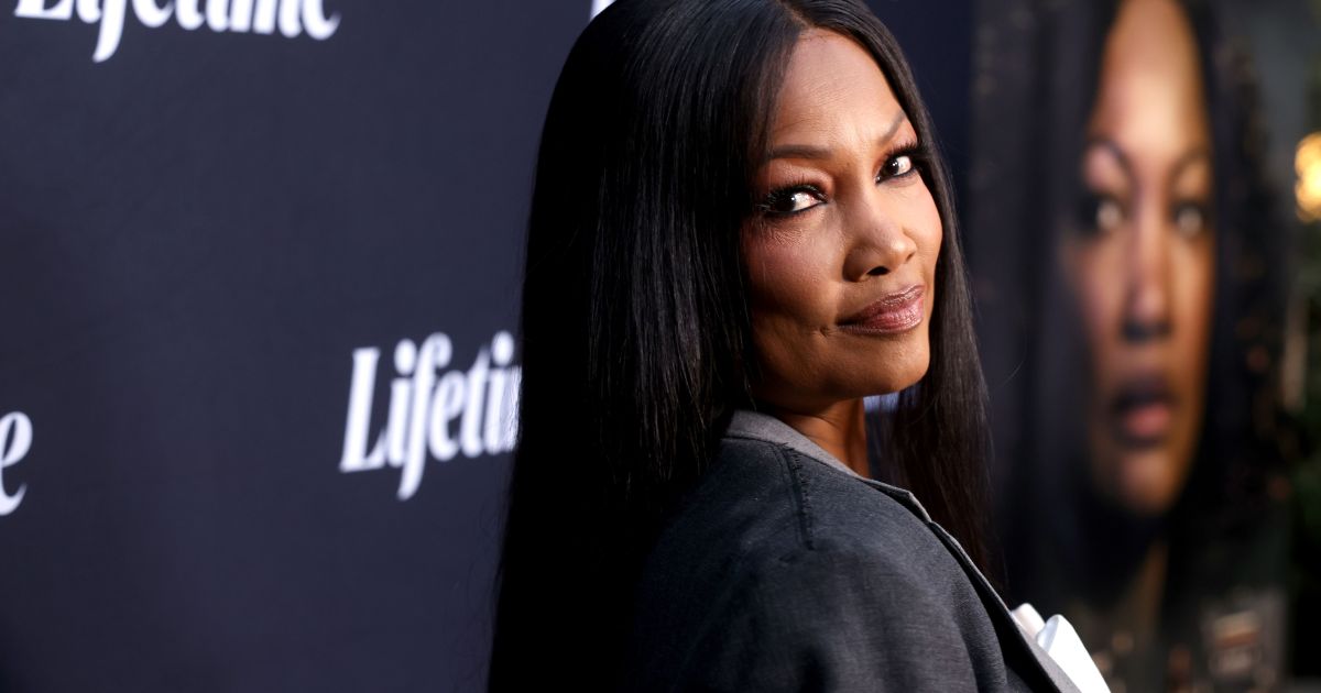 Garcelle Beauvais in a black blazer doing an over the shoulder pose at a Lifetime movie premiere