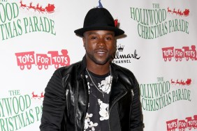 Joshua Allen posing at the Hollywood Christmas Parade wearing a black jacket and black hat