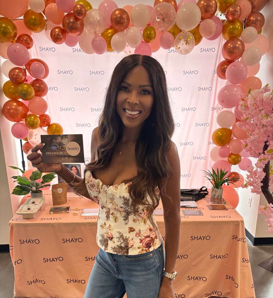 Stacey Rusch surrounded by pink balloons at an event for Shayo Wellness