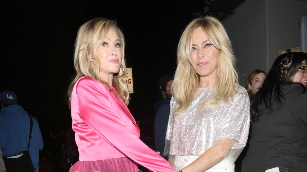 Kathy Hilton in a pink dress, grabbing the hand of Sutton Stracke