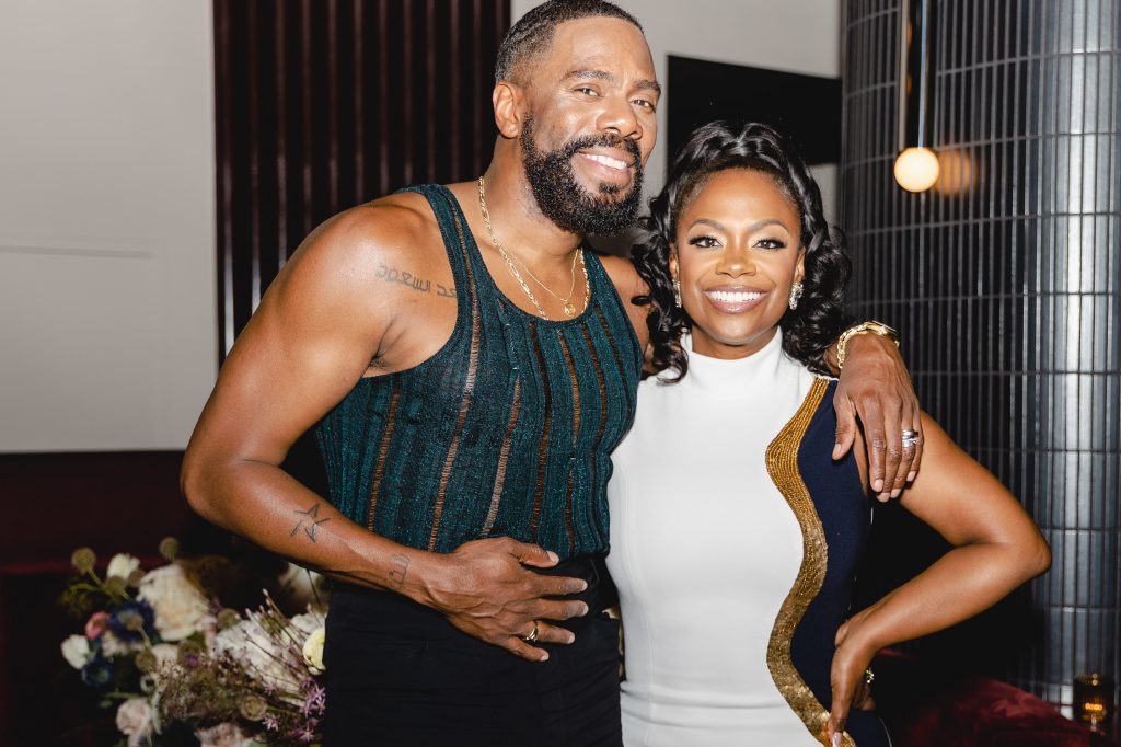 Colman Domingo in a mesh top, posing with his arm around Kandi Burruss