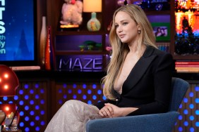 Jennifer Lawrence in a black blazer, sitting with her legs crossed on Watch What Happens Live
