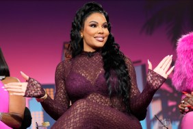 Mia Thornton in a burgundy bodysuit holding out her hands, on stage at Bravo Fan Fest Miami