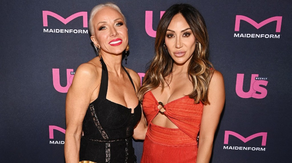 Margaret Joesphs in a black dress posing with her arm around Melissa Gorga, who is wearing red