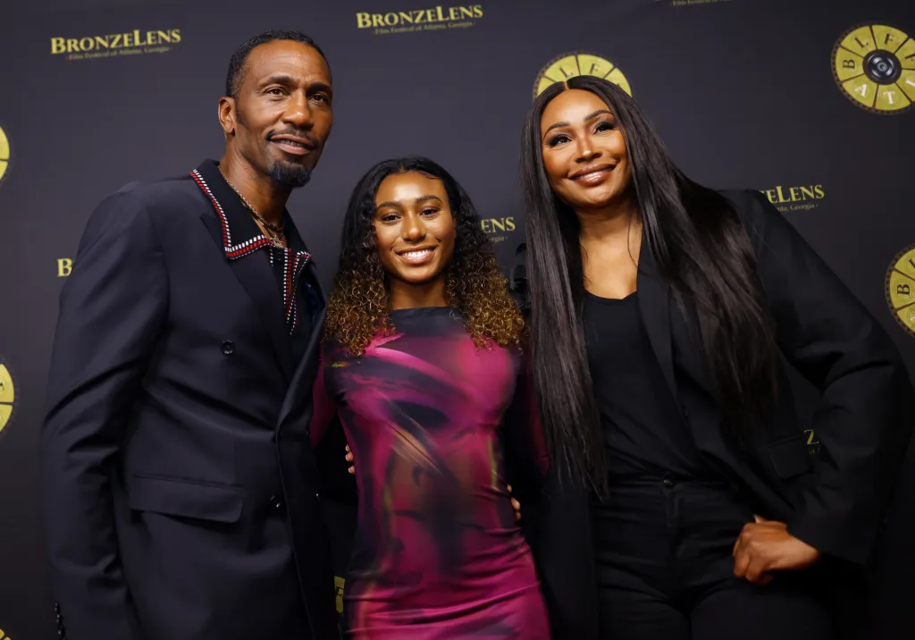 Leon Robinson, Noelle Robinson, and Cynthia Bailey posing on a red carpet together