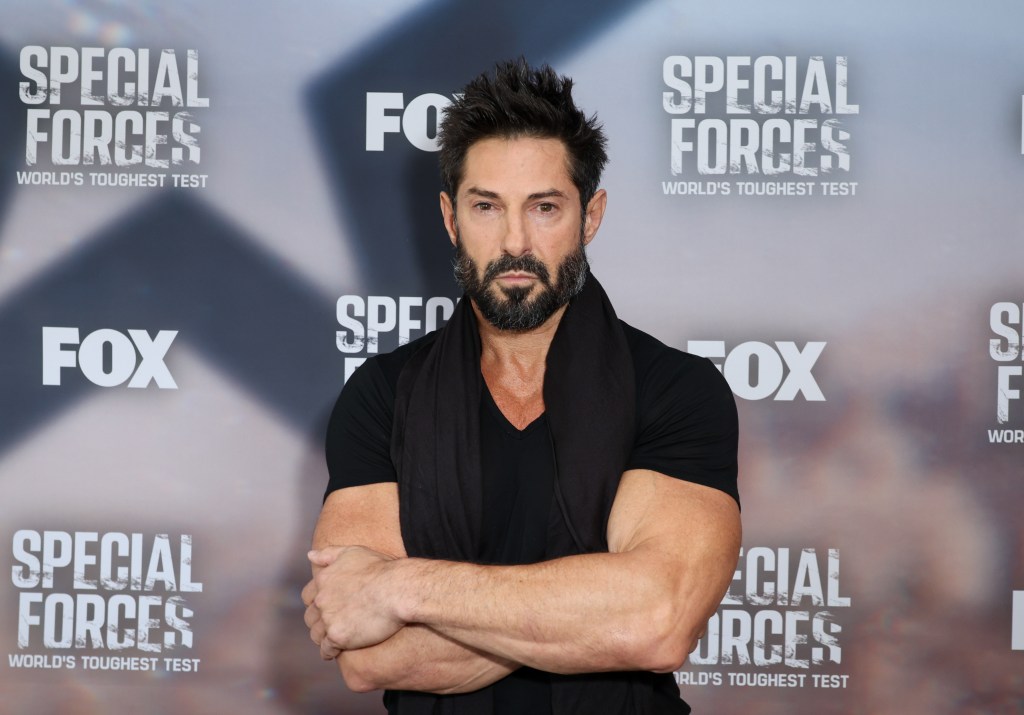Rudy Reyes in a black shirt posing with his arms crossed at the Special Forces premiere