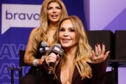 Tamra Judge sitting on stage at BravoCon, sitting in front of Teresa Giudice