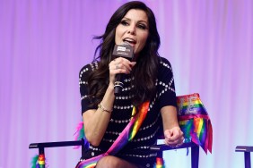 Heather Dubrow draped in rainbow flags and speaking into a microphone at BravoCon 2025