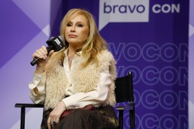 Kathy Hilton in a white fur vest sitting on stage with a microphone in her hand at BravoCon 2025