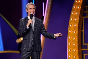 Andy Cohen in a sparkly pin stripe suit, standing on stage at BravoCon 2025