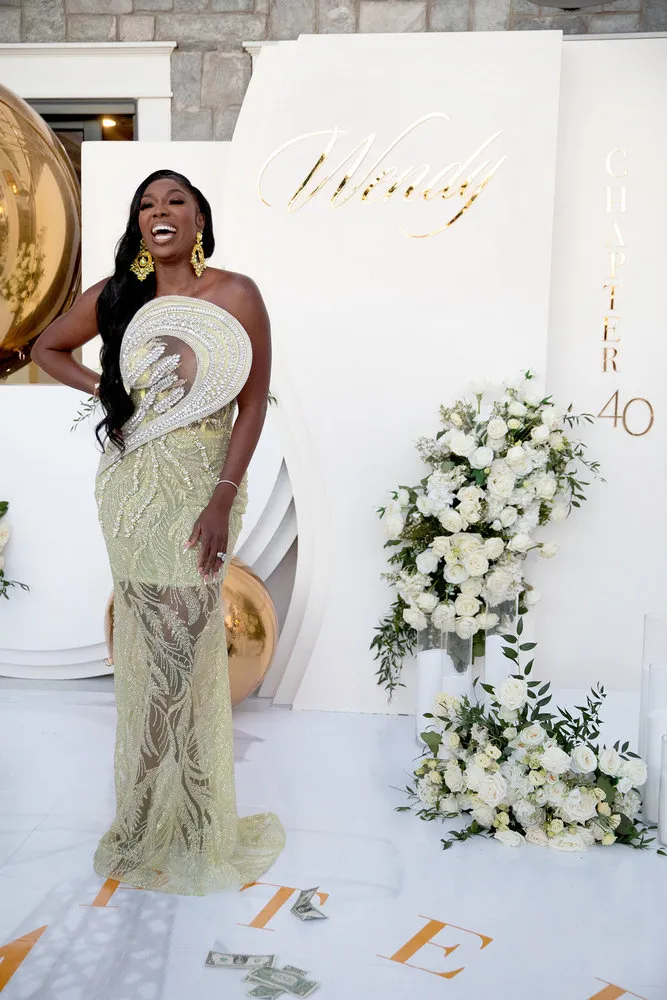 Wendy Osefo posing in a white gown with her hand on her hip 
