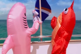 Meredith Marks in a pink inflatable Shark costume throwing a purple unicorn into the ocean, while standing next to Bronwyn Newport, in a red lobster costume