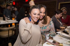 Charrisse Jackson Jordan sitting at a table in a restaurant with her arm around Ashley Darby