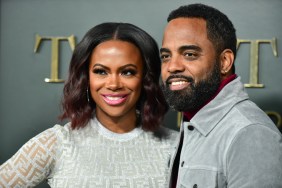 Kandi Burruss and Todd Tucker, both wearing gray, and posing together at a red carpet event