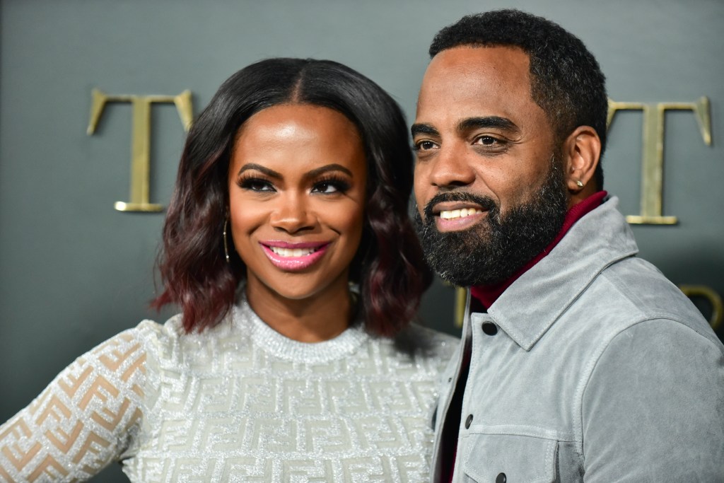 Kandi Burruss and Todd Tucker, both wearing gray, and posing together at a red carpet event