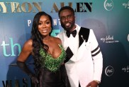 Wendy Osefo in a green and black gown standing with Eddie Osefo in a white suit