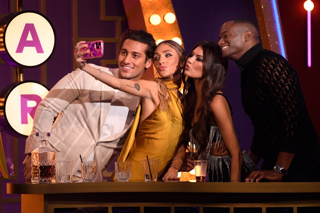 Joe Bradley, Maddi Reese, Grace Lilly, and Bradley Carter posing for a selfie on stage at BravoCon 2023