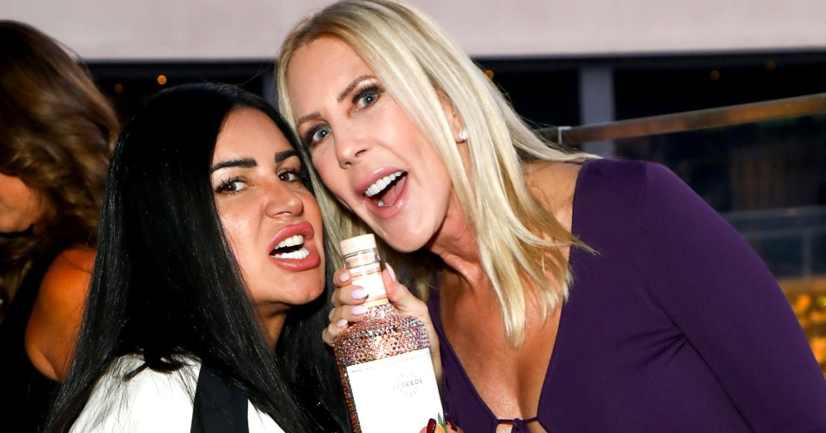 MJ Javid and Vicki Gunvalson, leaning over a bottle with their mouths wide open