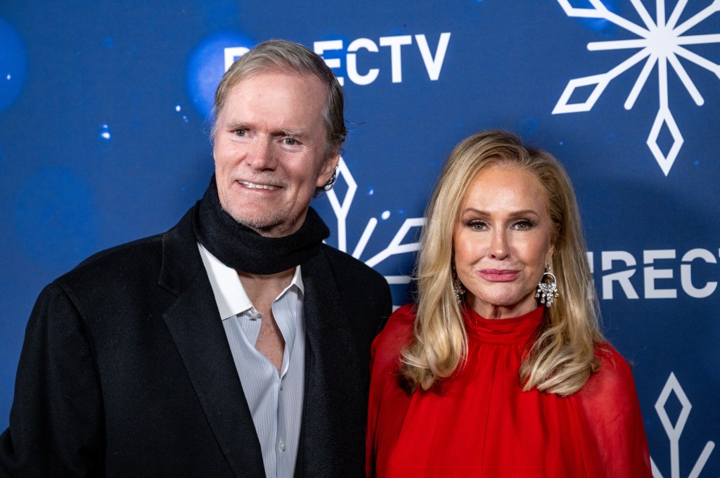 Rick Hilton in a black scar posing with Kathy Hilton in a red dress at a DIRECTV Christmas event