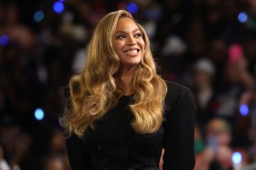 Beyoncé in a black suit, standing in front of a crowd at a Kamala Harris rally
