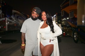 Kandi Burruss in a white bodysuit posing with Todd Tucker in a grey shirt