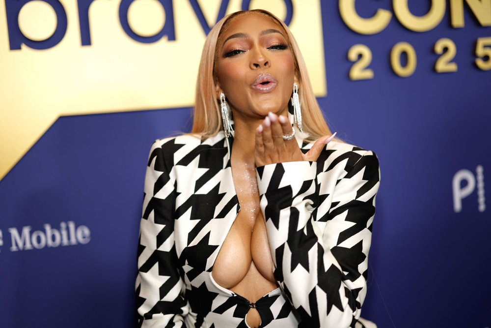 Drew Sidora blowing a kiss and wearing a houndstooth dress at BravoCon 2025 