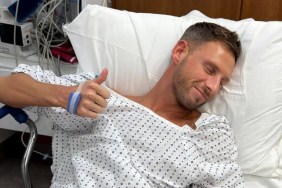 Fraser Olender laying in a hospital bed giving a thumbs-up to the camera