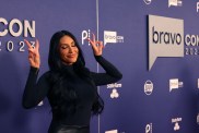 Monica Garcia at BravoCon 2023, wearing a black dress and holding up two peace signs