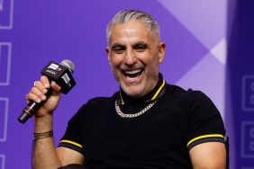 Reza Farahan on stage at BravoCon 2025, holding a microphone and laughing
