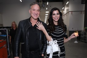 Terry Dubrow and Heather Dubrow walking arm in arm backstage at BravoCon, Heather has a glass of champagne