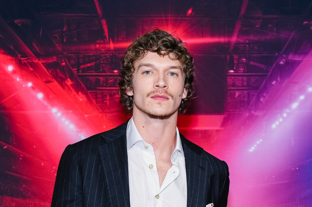 Connor Storrie in a navy blue pin striped suit at the Toronto premiere of Heated Rivarly