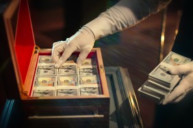 A hand pulling out money from a briefcase