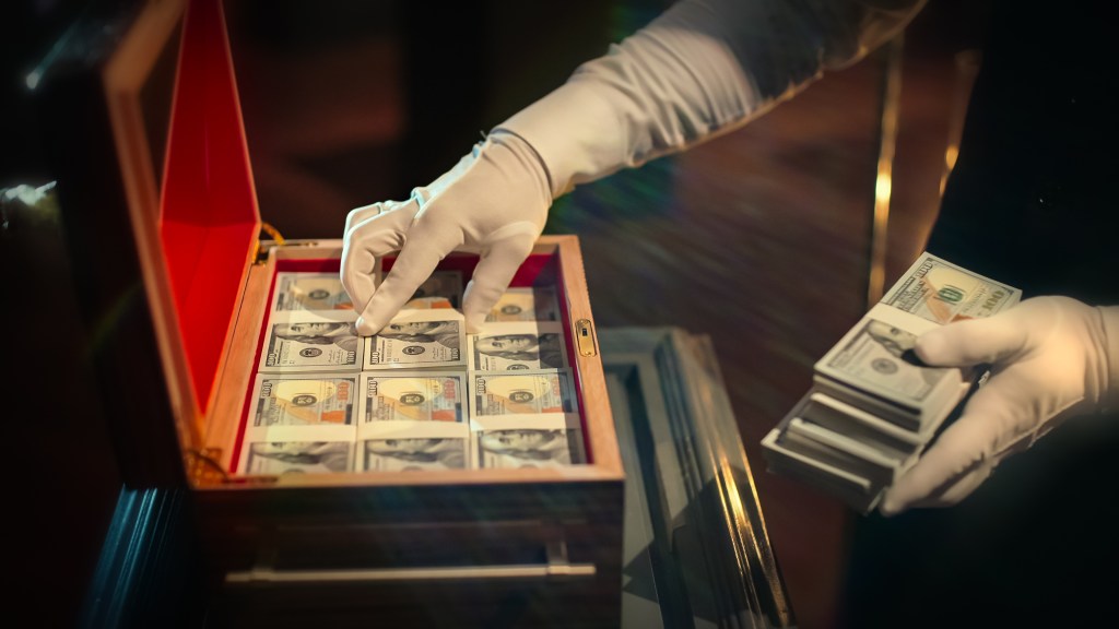 A hand pulling out money from a briefcase