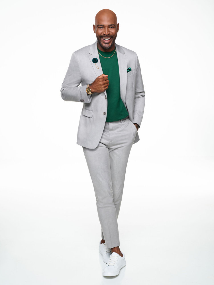 Karamo Brown in a grey suit and green shirt 