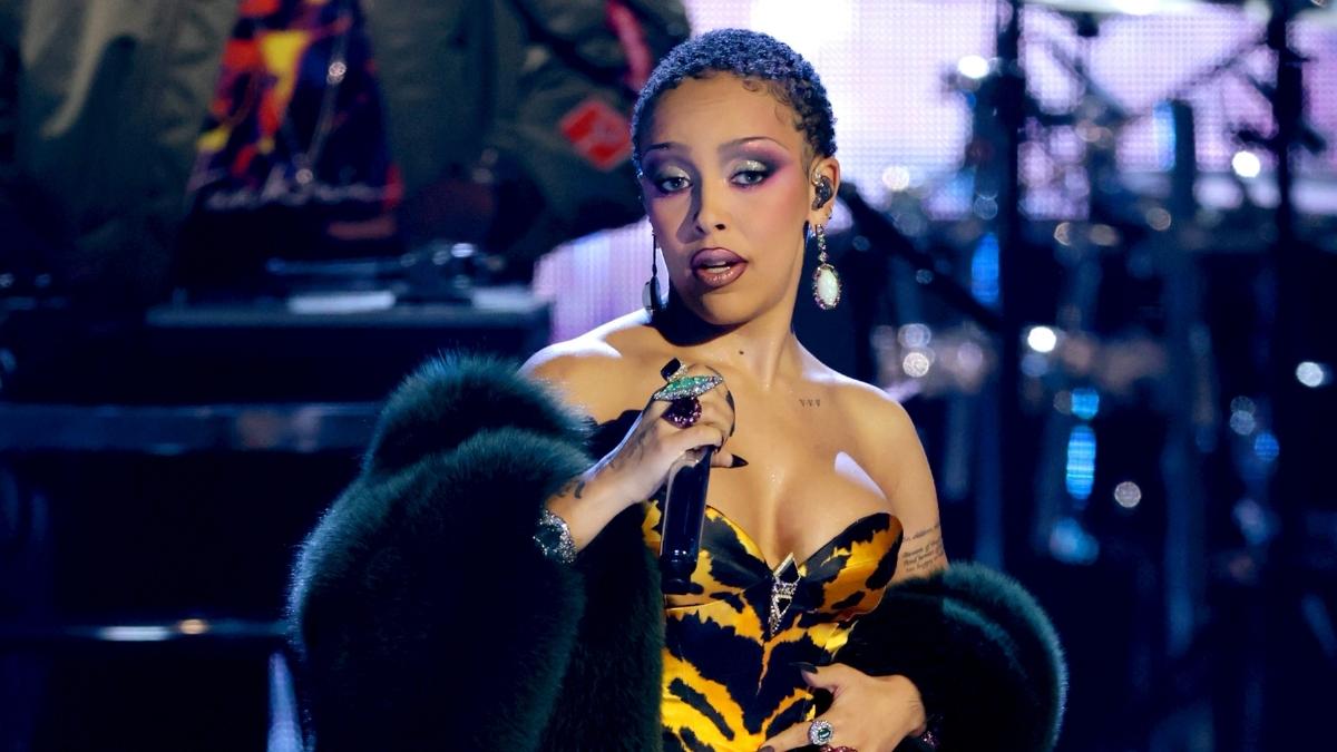 Doja Cat in colorful bikini set layered over black bodysuit with pink belt and pink wig, Tour Ma Vie 2026