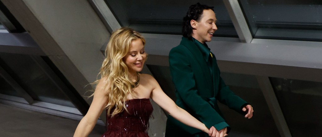Johnny Weir in a green walking hand in hand with Tara Lipinski, in a sparkly red dress