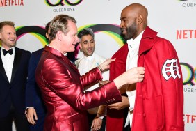 Carson Kressley and Karamo Brown, both wearing red and facing each other on a red carpet