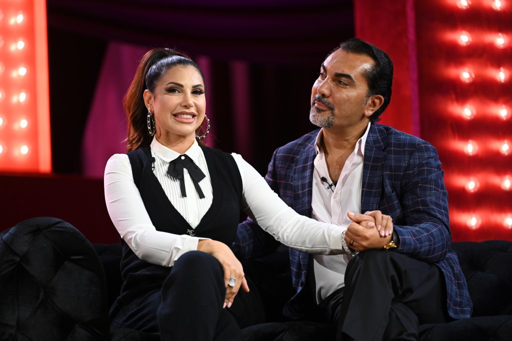 Jennifer and Bill Aydin holding hands on stage at BravoCon