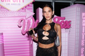 Lilah Gibney in a black top posing in front of pink White Fox signs