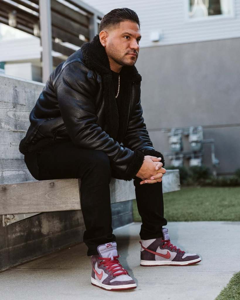 Ronnie Ortiz-Magro in a black outfit, sitting outside on a bench