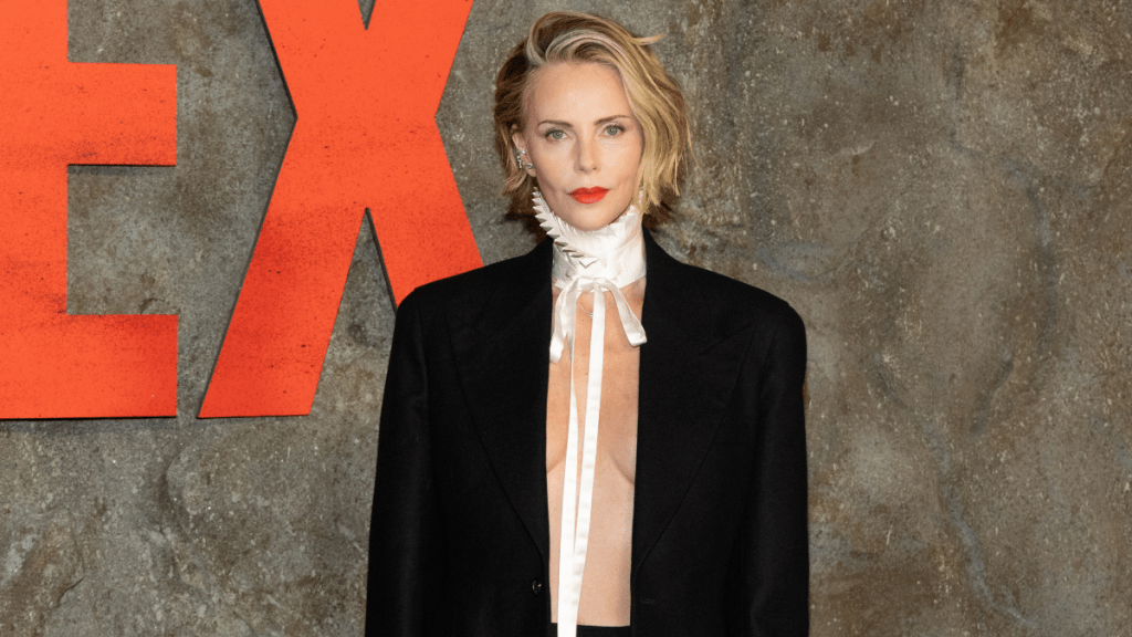 Charlize Theron Goes Topless & Braless Under Power Suit