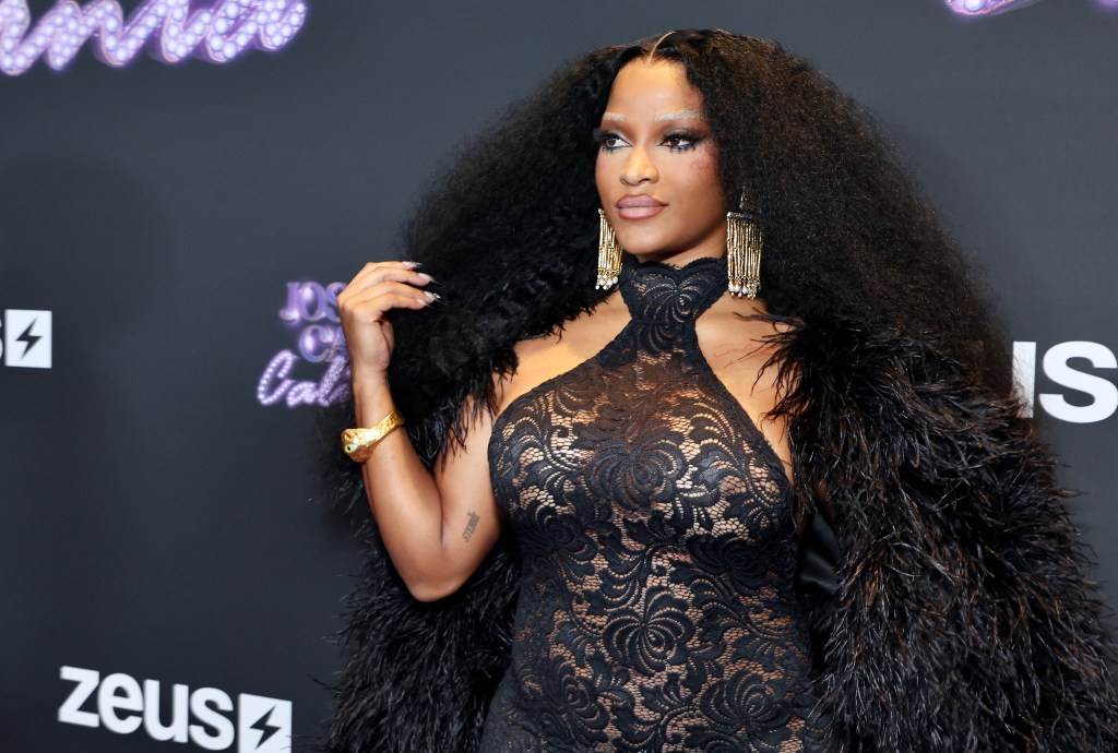 Joseline Hernandez wearing all black and a fur cape at the Joseline's Cabert California premiere