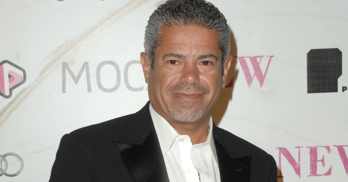 Lee Najjar in a black suit posing at a red carpet event