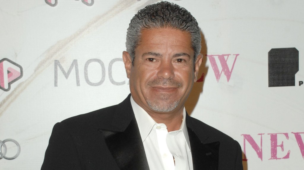 Lee Najjar in a black suit posing at a red carpet event