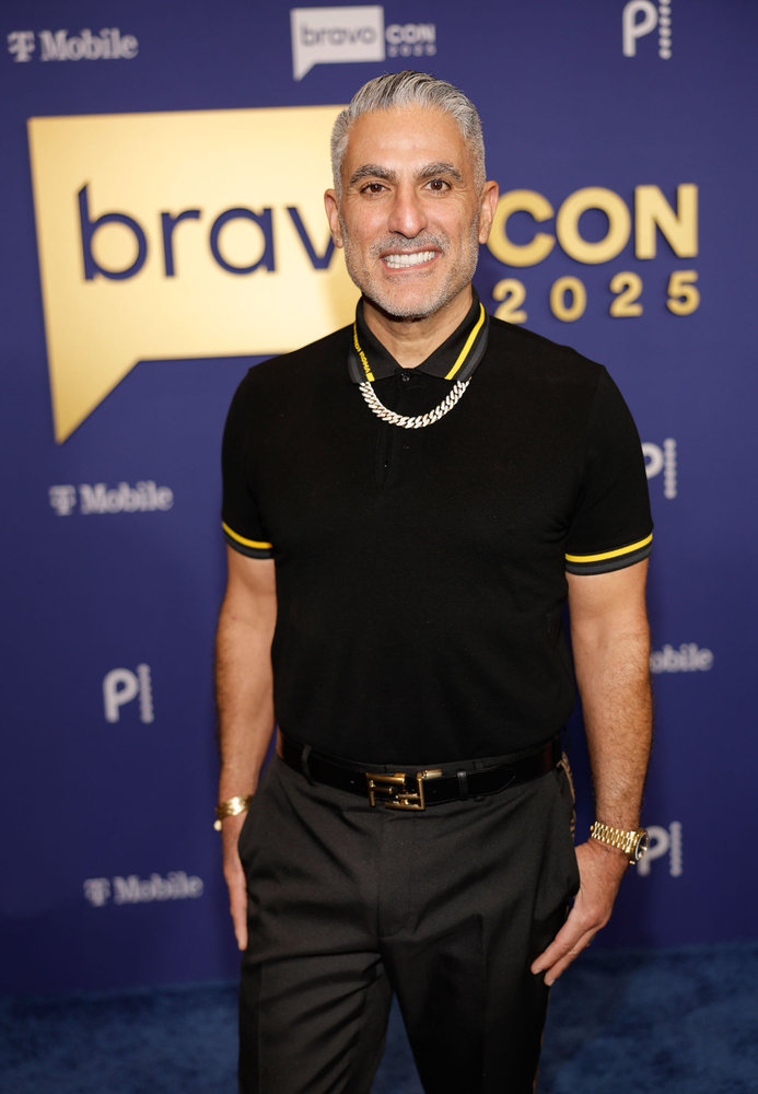 Reza Farahan at BravoCon 2025 in a black polo shirt 