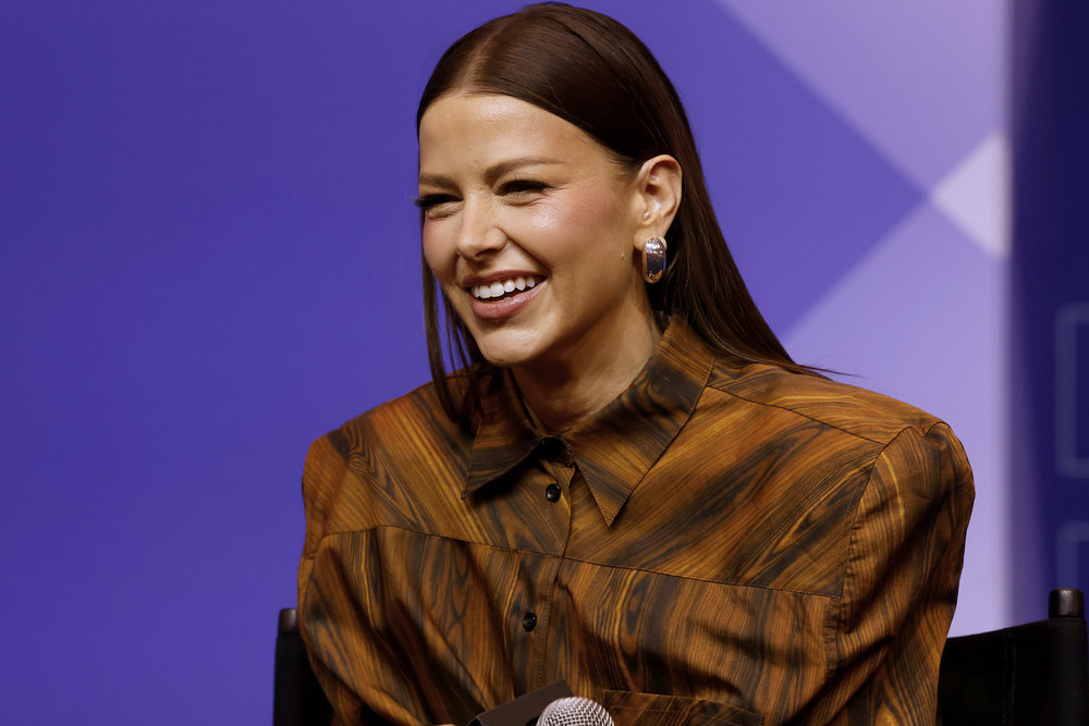 Ariana Madix in an orange blouse on stage at BravoCon 2025 